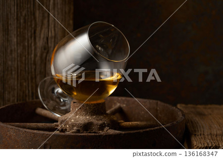 Cognac in snifter on old rusty wheel. 136168347