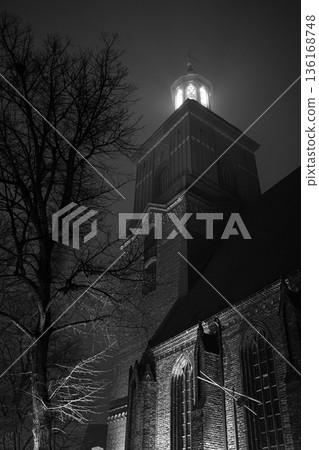 Illuminated Tower Between Narrow Old Town Streets at Night 136168748