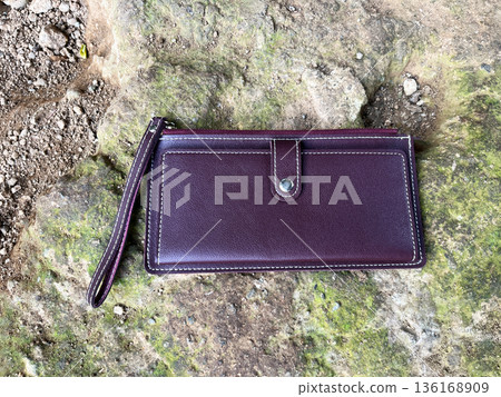 burgundy leather wallet with wrist strap lost in wild mossy rocks burgundy leather wallet with wrist strap lost in wild mossy rocks 136168909