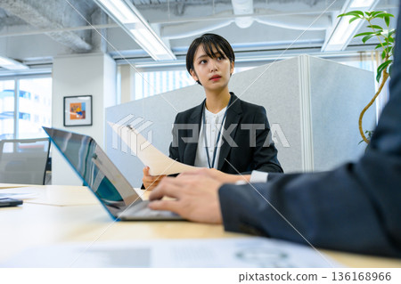 Serious female employee at interview Serious female employee at interview 136168966