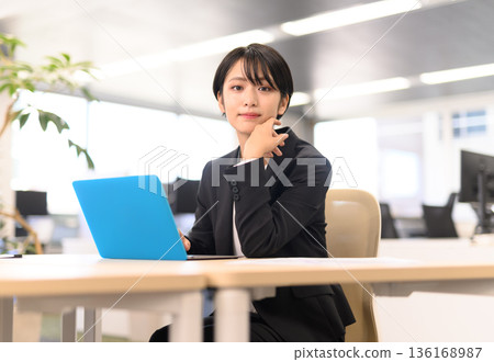 一位女士正在電腦前思考。 136168987