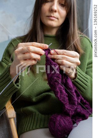 woman knits wool clothes knitting needles. skills of making clothes from yarn, hobbies meditation. woman knits wool clothes knitting needles. skills of making clothes from yarn, hobbies meditation. 136169252