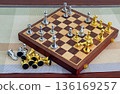 chessboard with golden and silver pieces isolated close-up 136169257