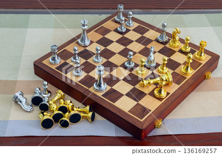 chessboard with golden and silver pieces isolated close-up chessboard with golden and silver pieces isolated close-up 136169257