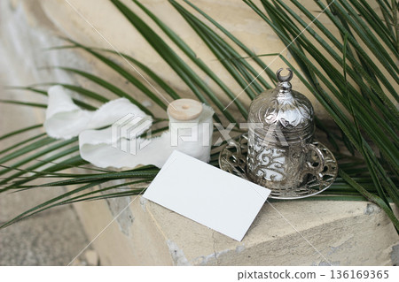 Blank White Business Card Mockup. Silver Arabic Turkish Coffee Cup. Palm Leaves. Blurred beige background. Ramadan, Eid Mubarak Still Life. Islamic Invitation, Branding, Wedding Stationery Background Blank White Business Card Mockup. Silver Arabic Turkish Coffee Cup. Palm Leaves. Blurred beige background. Ramadan, Eid Mubarak Still Life. Islamic Invitation, Branding, Wedding Stationery Background 136169365