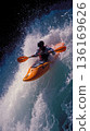 A man in an orange kayak paddling through a large wave 136169626