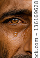 A close up of a man's eye with a drop of water on his face 136169628