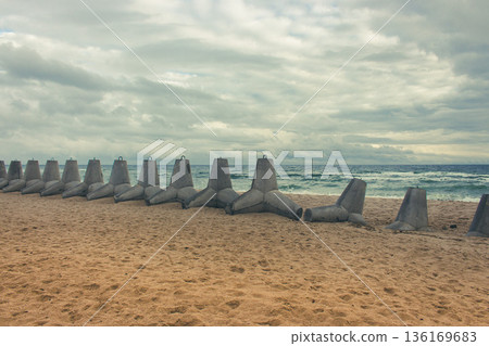 Tetrapods on the beach, Ukraine. Winter seascape with barrier blocks against russian invasion.Ukrainian coastal defense. Tetrapod in a row on sand. Seaside during war. Black Sea landscape Tetrapods on the beach, Ukraine. Winter seascape with barrier blocks against russian invasion.Ukrainian coastal defense. Tetrapod in a row on sand. Seaside during war. Black Sea landscape 136169683