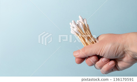 Hand holding eco-friendly bamboo cotton swabs for hygiene Hand holding eco-friendly bamboo cotton swabs for hygiene 136170591