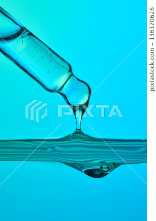 Pipette dripping blue serum fluid in wave Pipette dripping blue serum fluid in wave 136170628