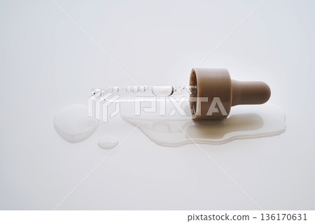 Skincare pipette dropping serum on white background Skincare pipette dropping serum on white background 136170631