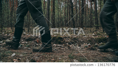 Low angle view of two Wehrmacht soldiers walking in boots through forest 136170776