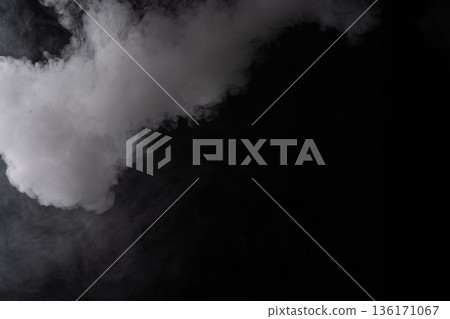 White smoke, fog, and steam creating a mysterious, thick, and ethereal atmosphere on a dark background White smoke, fog, and steam creating a mysterious, thick, and ethereal atmosphere on a dark background 136171067