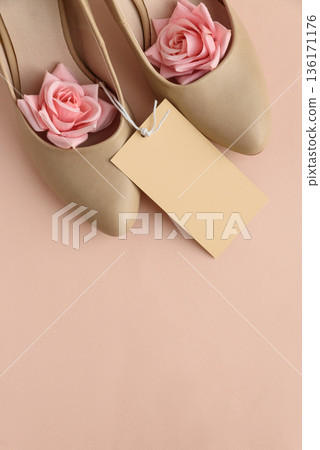 Beige High Heels with Roses and Gift Tag on Peach Background Beige High Heels with Roses and Gift Tag on Peach Background 136171176