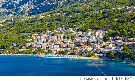 Aerial view of Makarska Riviera coastal town in Croatia with turquoise Adriatic Sea and green mountains Aerial view of Makarska Riviera coastal town in Croatia with turquoise Adriatic Sea and green mountains 136171624