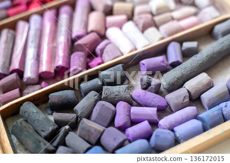 Soft pastel crayons set in pink and lilac, viewed from above. Art supplies for pastel painting and drawing in a wooden box 136172015