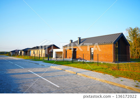 Modern Barnhouse in suburban. Barn raising. Suburb houses Rows along road. Prefab house. Modern Barnhouse in suburban. Barn raising. Suburb houses Rows along road. Prefab house. 136172022