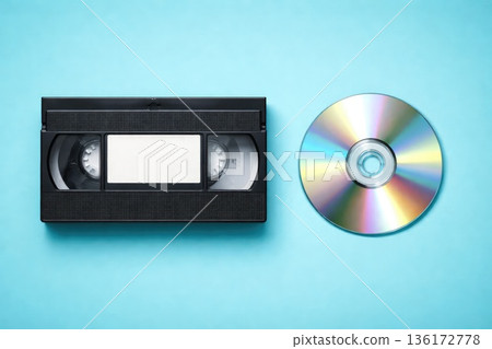 VHS Cassette Tape and Compact Disc on Blue Background Retro and Modern Media VHS Cassette Tape and Compact Disc on Blue Background Retro and Modern Media 136172778
