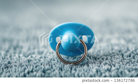 Blue Baby Pacifier Lying on Soft Carpet in Cozy Home Interior Close-Up 136172786