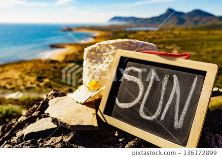 Black board with word sun against sea coast Black board with word sun against sea coast 136172899
