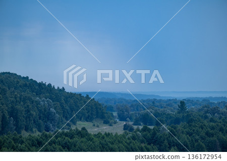 Rainy landscape of countryside forests and valley. Wet summer weather, rainy clouds in the sky, calm nature 136172954