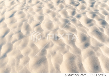 Close up of sand on beach. Clean sand with waves made by wind, beautiful nature texture 136172997
