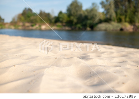 Close up of sand beach on river. Sunny day on river sandy beach, place for swimming 136172999