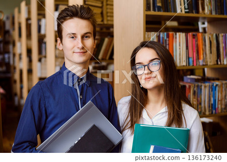 Portrait of two students in the library. University students studying in the library 136173240
