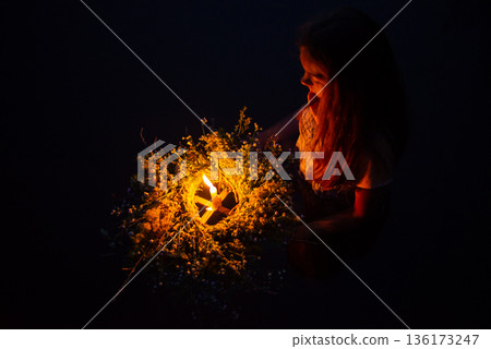 Young girl in dress on the river with a wreath sets it float. Pagan traditions at Kupala night 136173247