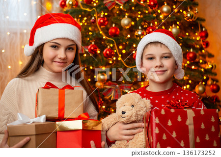 Children with many presents under christmas tree. Christmas morning, receiving presents from Santa concept Children with many presents under christmas tree. Christmas morning, receiving presents from Santa concept 136173252