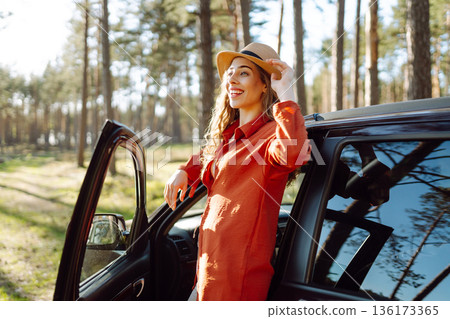 Stopping during a car trip. Young woman enjoying nature. Journey by car. Lifestyle, travel, tourism 136173365