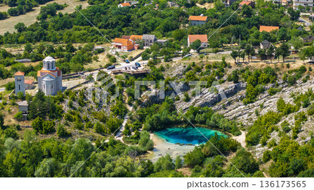 Aerial view of Cetina River source near Vrlika Croatia with turquoise karst spring village and historic church 136173565