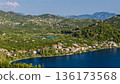 Aerial view of Dalmatian karst lake village in Croatia with waterfront houses green hills and calm water 136173568