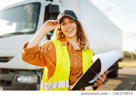 Portrait of woman truck driver in casual clothes standing in front of truck. Transport industry 136173653