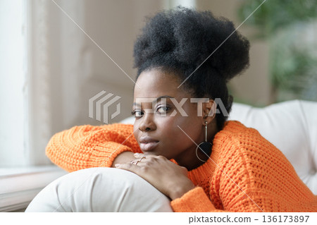 Trendy African millennial woman in casual clothing and curly hair lying on couch, relaxing at home Trendy African millennial woman in casual clothing and curly hair lying on couch, relaxing at home 136173897