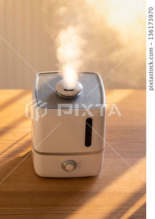 Close up of aroma oil diffuser on the table at home, steam from the air humidifier, top view 136173970