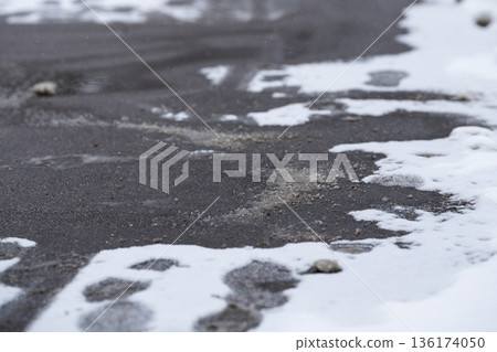 Deicing chemicals on street in winter. Slippery road sprinkled with technical salt. Prevent slipping Deicing chemicals on street in winter. Slippery road sprinkled with technical salt. Prevent slipping 136174050
