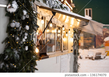 New year's street cafe bistro wagon decorated in christmas lights and spruce garland with ornaments. 136174070