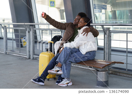 Happy couple of tourists take selfie at airport after arrival, loving african man and woman travel 136174090