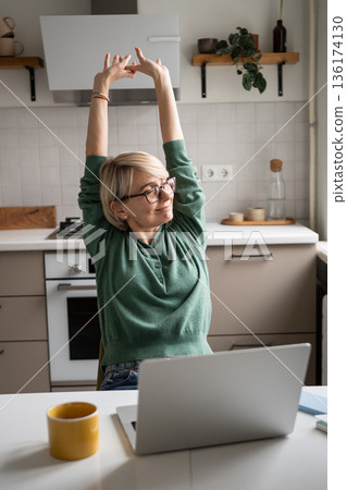 Satisfied relaxed businesswoman warming up body and arms after successfully finishing work tasks. Satisfied relaxed businesswoman warming up body and arms after successfully finishing work tasks. 136174130