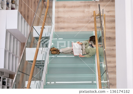 Diligent female student prepares for coursework in philosophy reading books to find information Diligent female student prepares for coursework in philosophy reading books to find information 136174182
