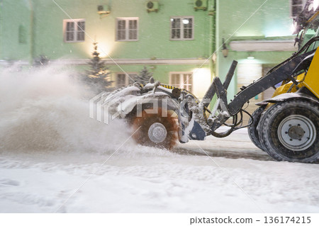Cleaning snow from road. Snowplow tractor in city blow snow from street for transport traffic safety Cleaning snow from road. Snowplow tractor in city blow snow from street for transport traffic safety 136174215