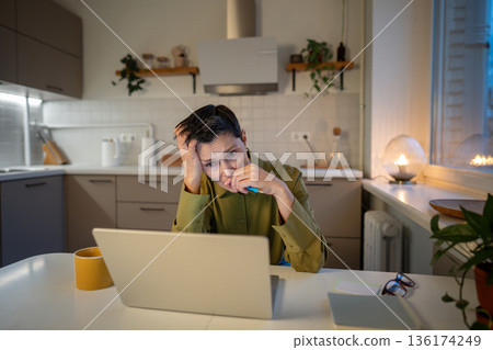 Overworked anxious senior businesswoman works under pressure, helplessly staring at laptop screen. Overworked anxious senior businesswoman works under pressure, helplessly staring at laptop screen. 136174249