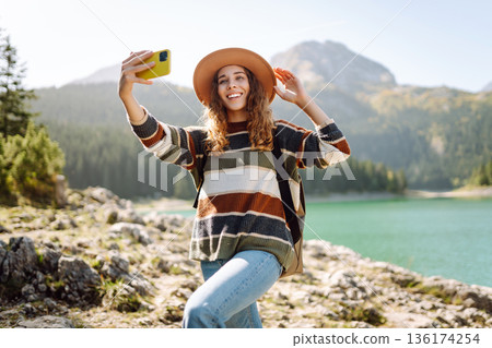 Happy tourist woman taking picture outdoors for memories. Selfie time. Lifestyle, active life. Happy tourist woman taking picture outdoors for memories. Selfie time. Lifestyle, active life. 136174254