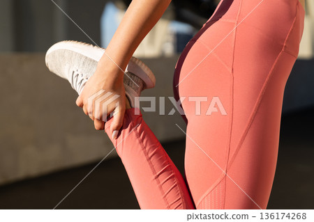 Close up of sporty female stretching leg muscles before run. Jogging, workout and fitness concept Close up of sporty female stretching leg muscles before run. Jogging, workout and fitness concept 136174268