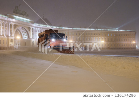 Professional snow removal equipment clearing place square at night after intense snowfall in city 136174296