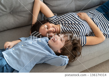 Top above view of happy young mom and little kid son relaxing on sofa at home, dreaming together 136174314