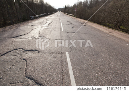 Bad quality road with potholes. Hole in asphalt. Pit, unsafe, hole road. Transportation Bad quality road with potholes. Hole in asphalt. Pit, unsafe, hole road. Transportation 136174345