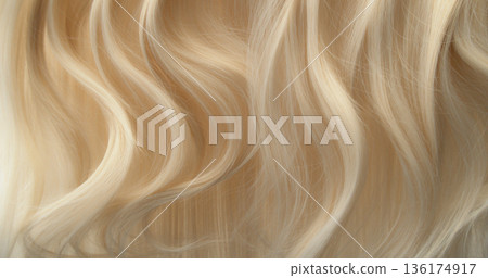 Close-up abstract texture of flowing blonde hair forming soft natural waves. Elegant curves, fine strands and warm tones create a luxurious beauty background ideal for cosmetic, fashion or haircare 136174917