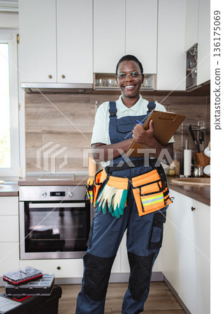 Smiling african american female technician working in kitchen Smiling african american female technician working in kitchen 136175069